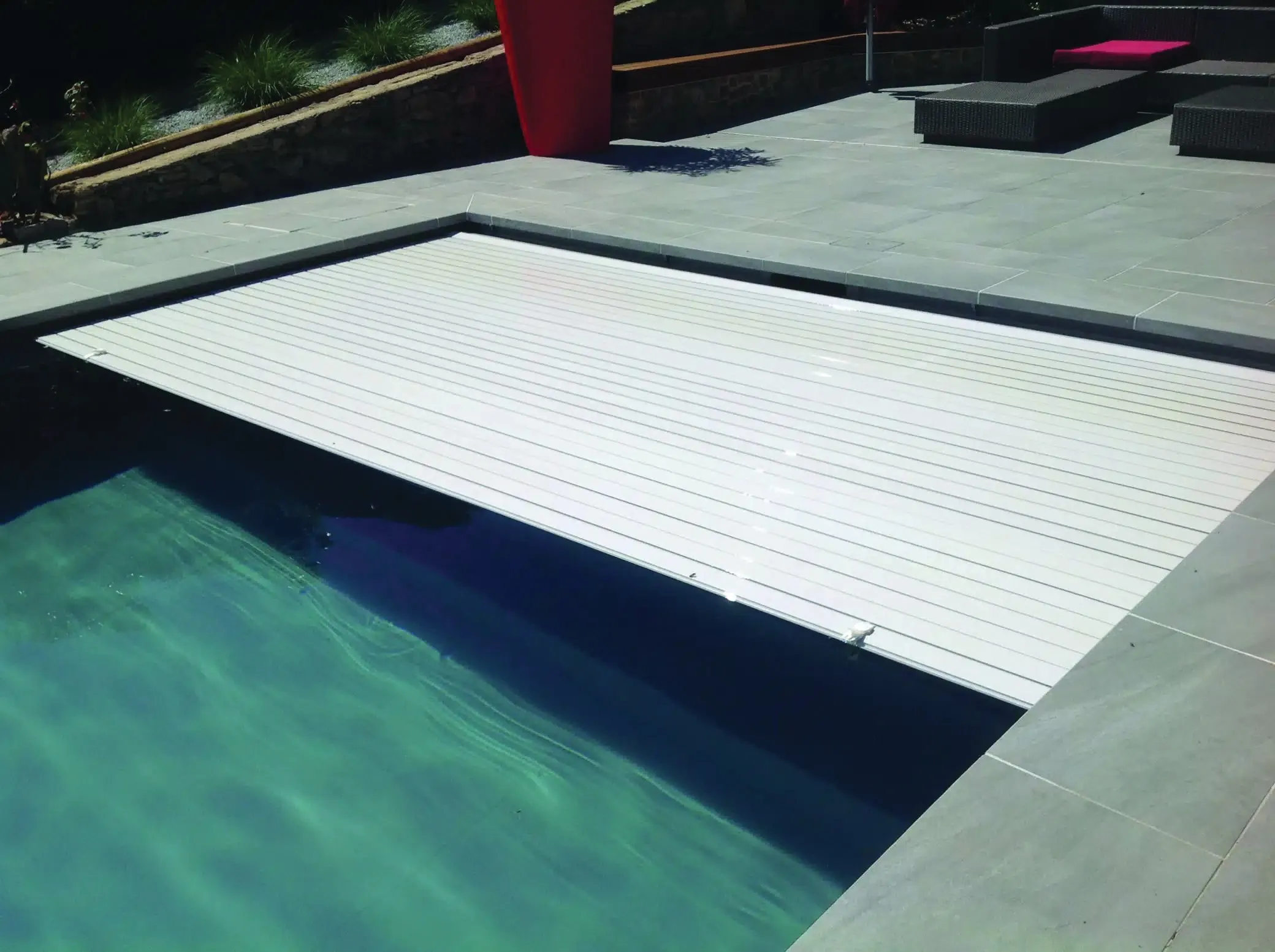 Volet immergé à lames blanches sur une piscine